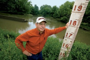 Warsaw, Illinois, farmer and chairman of the local drainage district, Sam Zumwalt, age 64, with the flood gage at the Hunt Drainage District pumping station. He has long been a champion of better flood control for the 16,000 acres of lowlands that make up the district. Water from the nearby Mississippi River reached 25-feet above flood stage in both 1993 and 2008. In the background is the outlet from the pumping station that can pump 200,000 gallons of water per minute off of the nearby farmland through a series of ditches and canals.