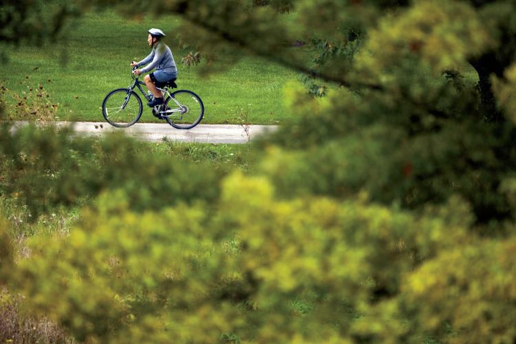 A bicyclist rides at Waubonsie Lake Park, part of the Fox Valley Parks District, in Aurora.