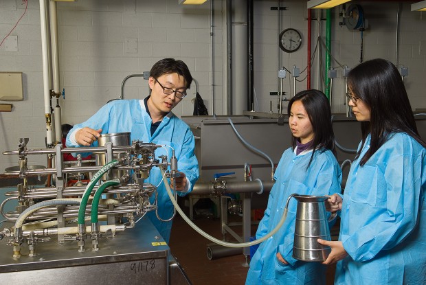 Youngsoo Lee with ultra-high-temperature processing unit. Quaker Oats donated the machine to University of Illinois ACES.