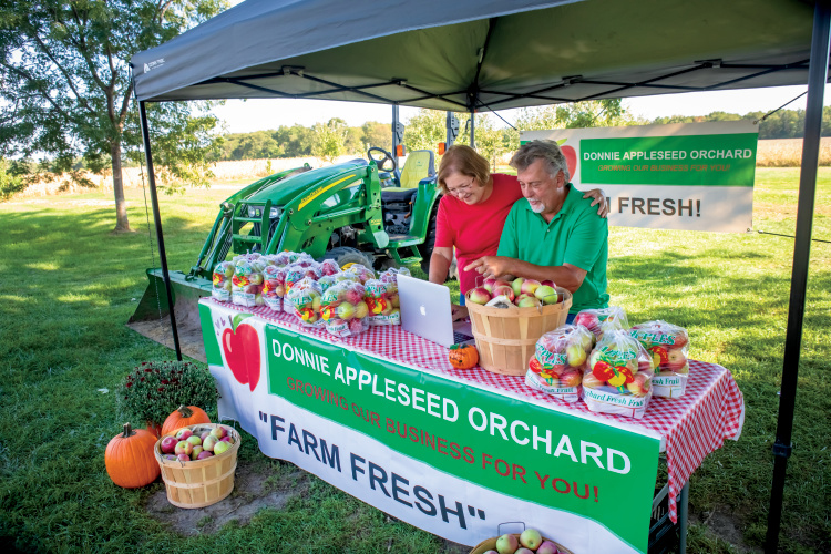 Don and Wendy Wenzel working on their digital marketing at their fruit stand in between customers. LaSalle County Farm Bureau members Don and Wendy Wenzel run a 100-acre, third-generation family farm called Donnie Appleseed Orchard, which has 250 apple trees along with 5 acres of fresh produce, including garlic, onions, green beans and tomatoes. They sell their produce at three area farmers markets, as well as their farm/orchard. What makes them stand out from the crowd is how they communicate with their customers – and broaden their reach – using social media. Their email newsletter offers coupons and provides recipes using in-season produce, and they use an app called FarmFan that lets customers get real-time updates on market days about produce availability, and also offers loyalty discounts. They’re also active on Facebook and Pinterest.