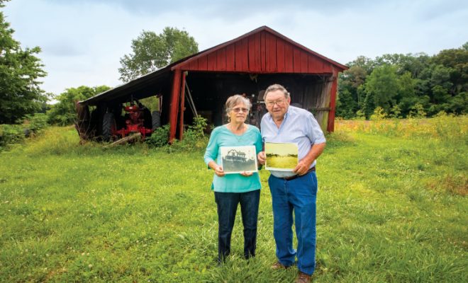 Gerald and Betty Brown of Jonesboro, Illinois, holding historic photos on their bicentennial farm.