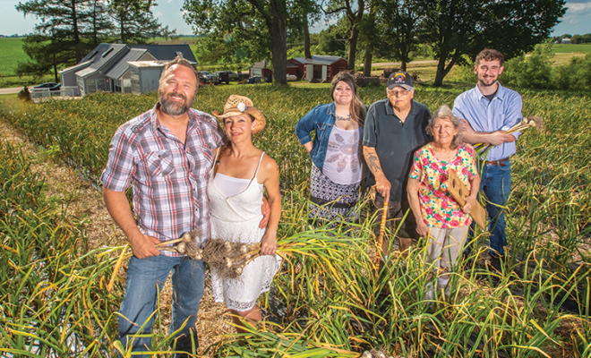 Garlic Breath Farm family standing next to garlic plants