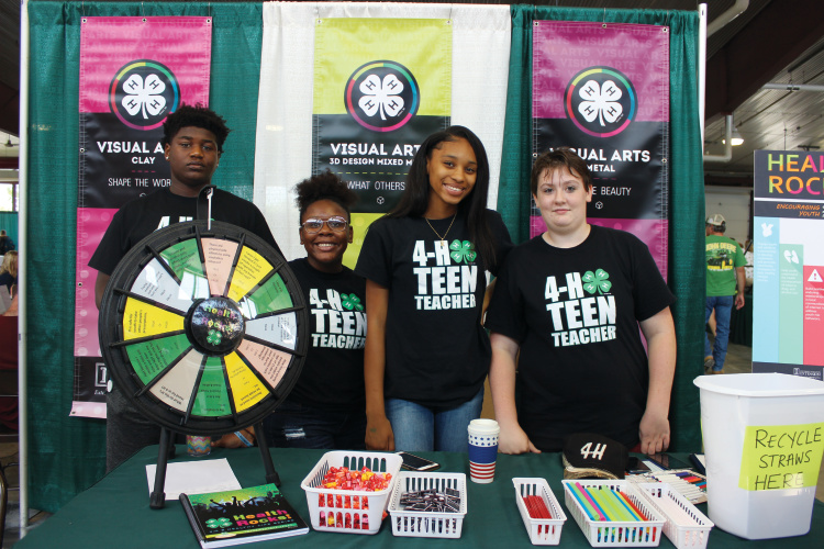4-H members pose at booth