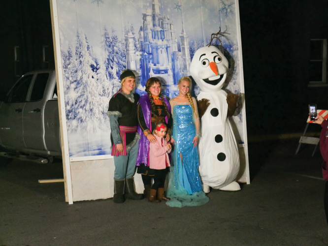 Kids pose for a photo with characters at Christmas Uptown Festival