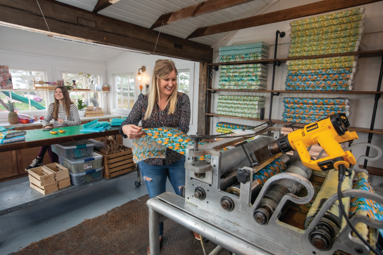 Colleen Flinn moves fabric through a custom-built machine that coats it with beeswax