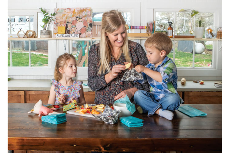 Colleen Flinn and her children enjoy a snack and pack food away into her Nothing Fancy beeswax food wraps