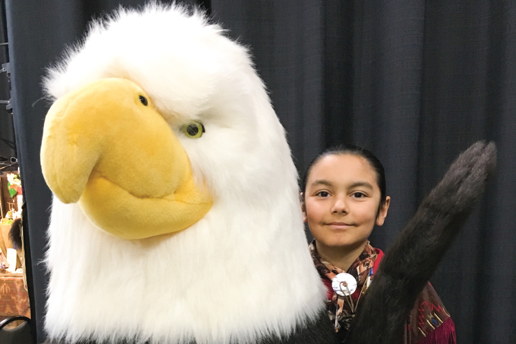 Girl poses with large stuffed animal eagle