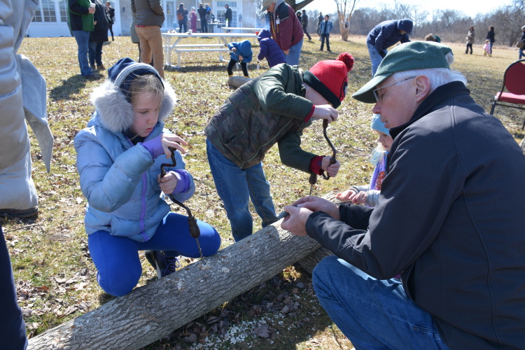 Kids learn how to tap a maple tree at the festival 