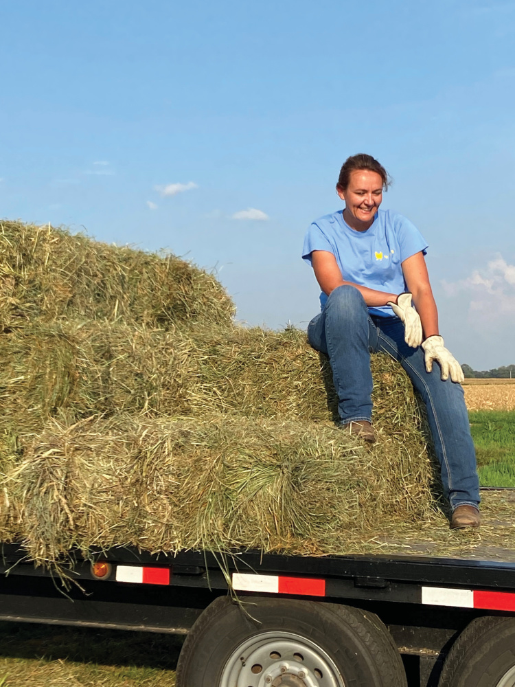 Katie King sitting on hay bales
