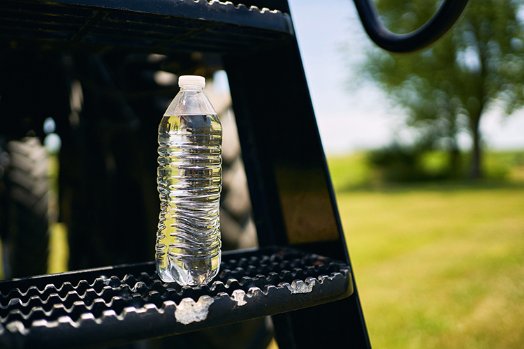 Water bottle on the steps of a sprayer