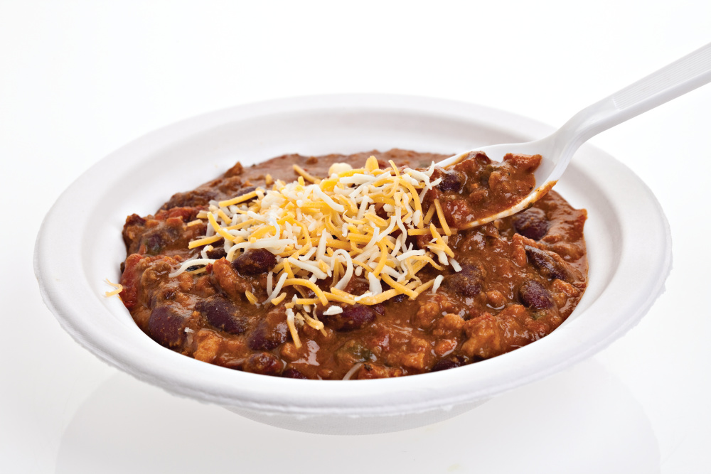 Bowl of chili with shredded cheese on top 