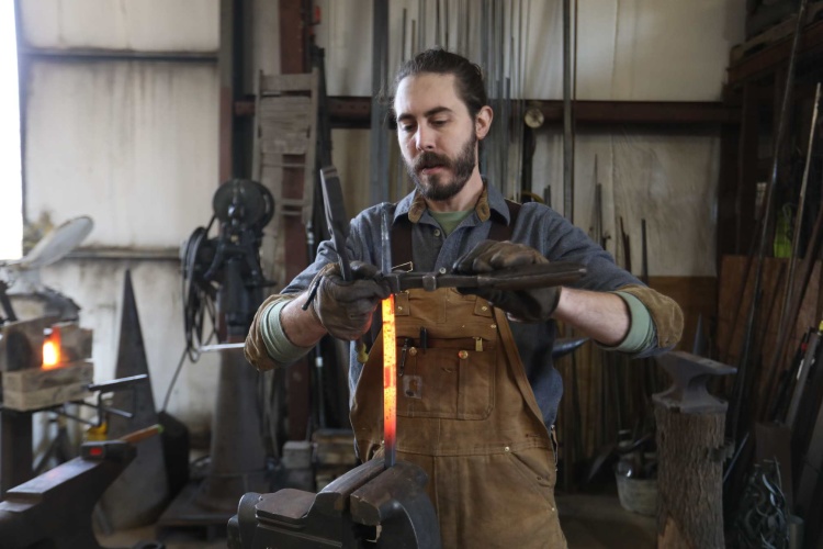 Nicholas Burke twists a heated rod into a design 