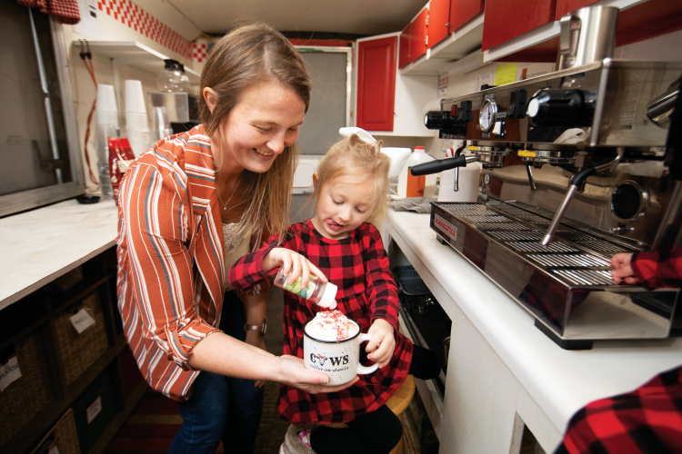 Katlyn Sanden makes hot chocolate with her daughter Emery in her mobile coffee stand