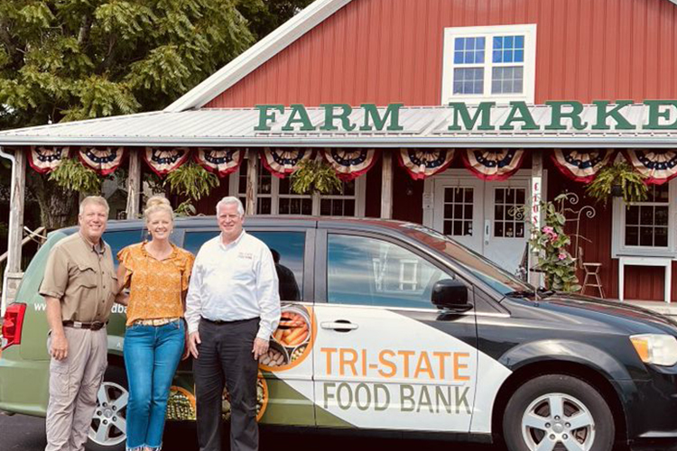 Rendleman Orchards pose with a Tri-State Food Bank vehicle in front of the Farm Market store