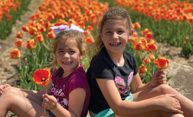 Two girls sitting in the tulip field