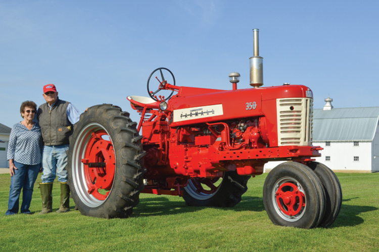 Leah and Pat Strom by a restored tractor
