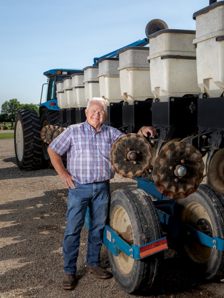 Dennis Green stands with his planting equipment
