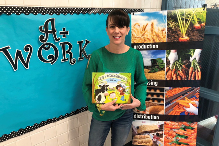 Eva Manske poses with kids agricultural books in her classroom