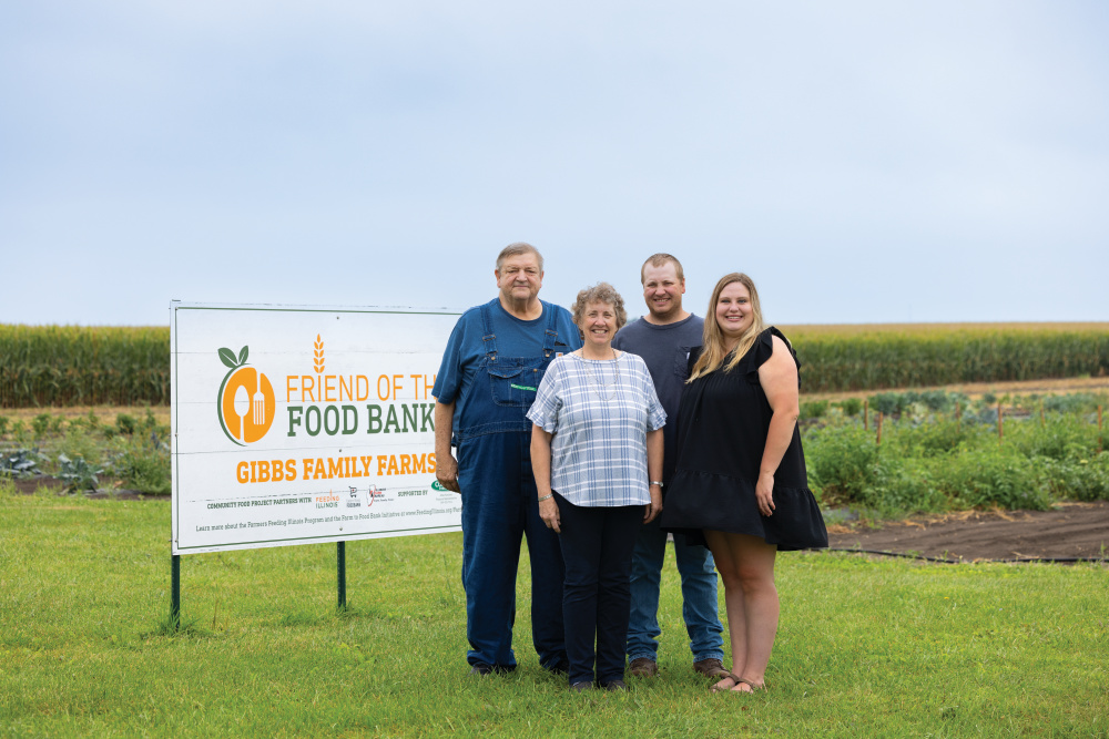 The Gibbs family standing next to their farm sign
