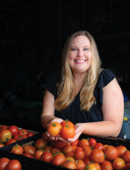 Ali Gibbs with tomatoes that will be donated to the Farm to Food Bank program