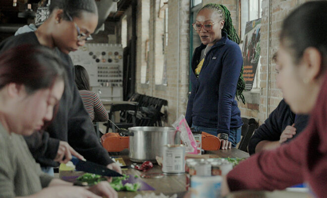 Selma Sims looks on as a group of volunteers prep a dish