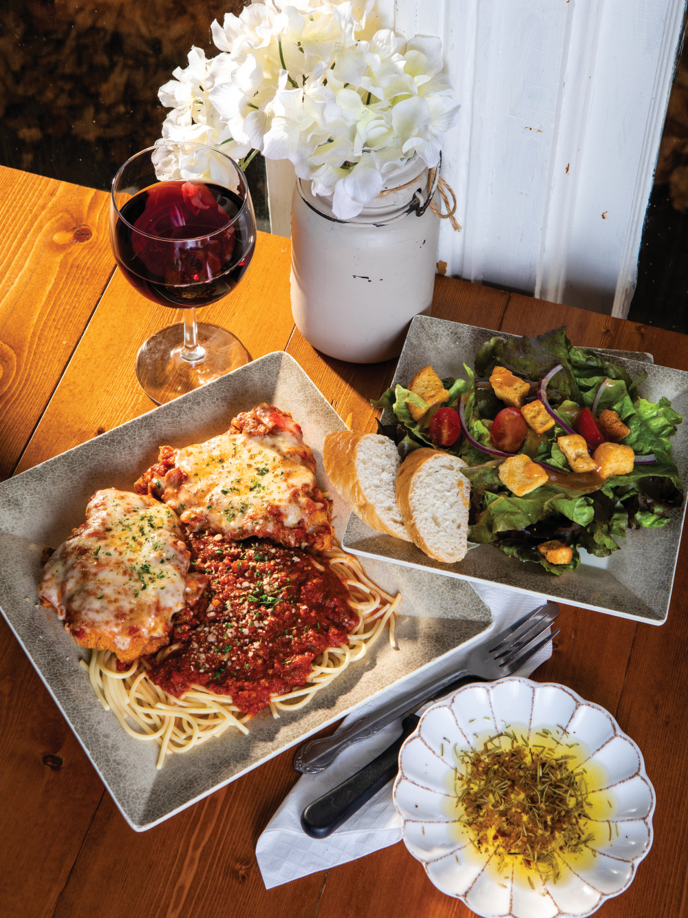 Chicken parmesan and a salad with a glass of wine from Nucci’s Pasta House 