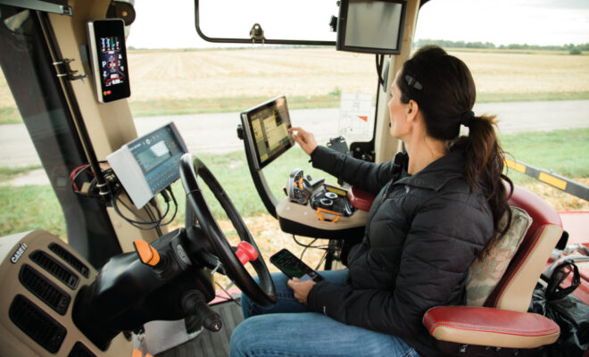 Joanie Stiers operating a tablet in the cab of a tractor