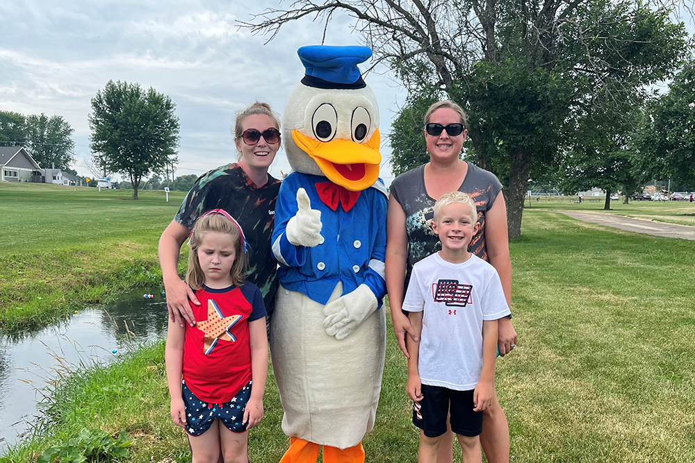 A family poses with Donald Duck at the Fourth of July Festival