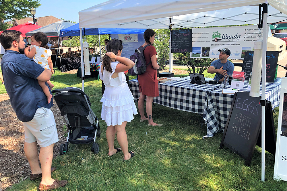 Joe Wanda, a farmer from near Harvard, has customers waiting in line for his products at the downtown Crystal Lake Farmers Market held on Saturdays.