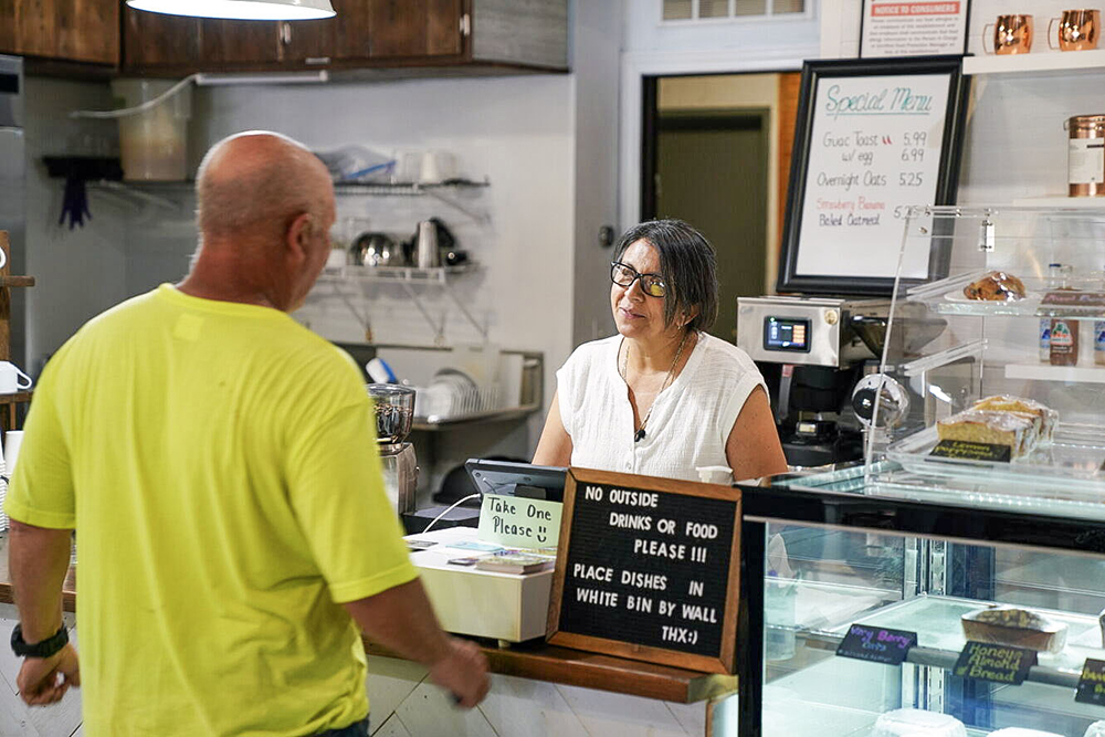 Marta Vidal talks with a customer at her coffee shop
