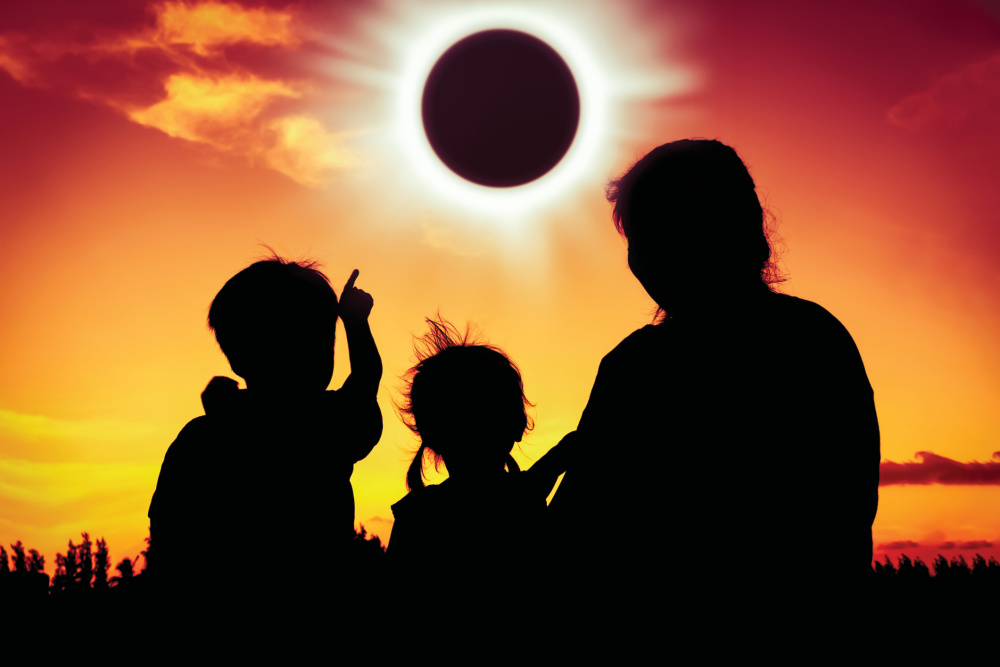Family silhouetted viewing the eclipse