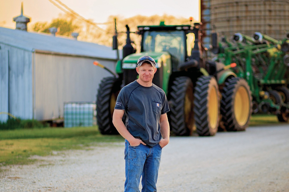 Nathan Ring standing in front of a John Deere tractor 