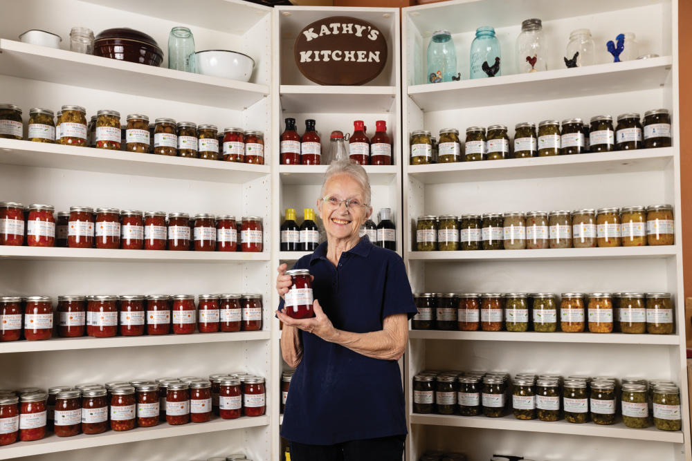 Kathy Keylor standing in front of shelves with her canned goods on them