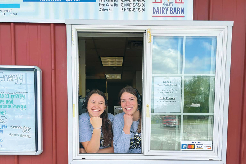 Two workers pose for a photo at the order window of 4-Ways Dairy Barn