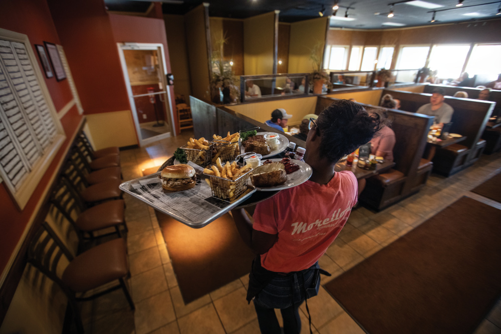 Waitress carries a tray of food at Morello's