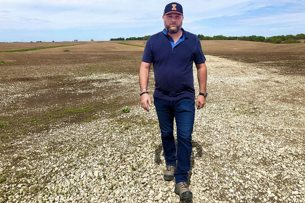 Robert Ehnle of Henry County holds a sign depicting R. Ehnle Farms made by his cousin. The fourth-generation farmer and veteran hopes his story of living with Post Traumatic Stress Disorder encourages others who are struggling to ask for help.