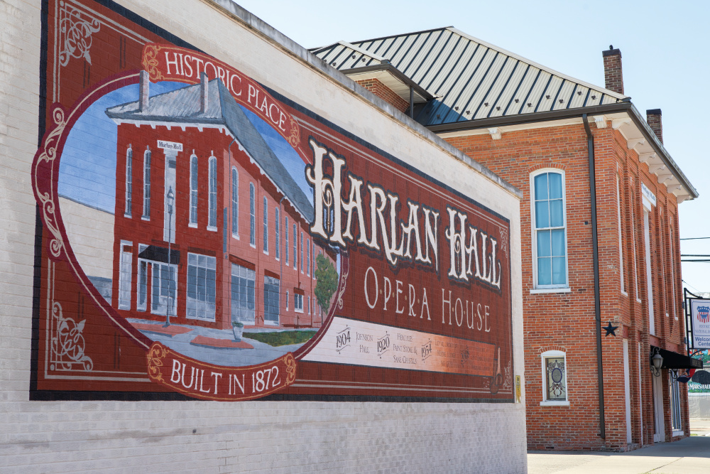 Harlan Hall Opera House mural with the opera house in the background