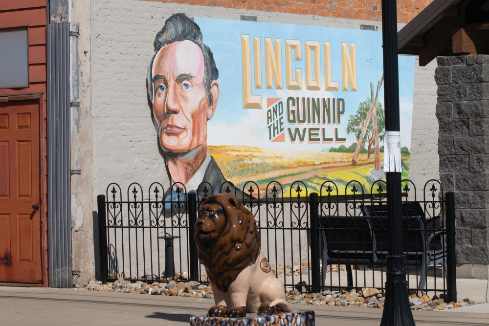 Abraham Lincoln mural and a lion statue in downtown Marshall 