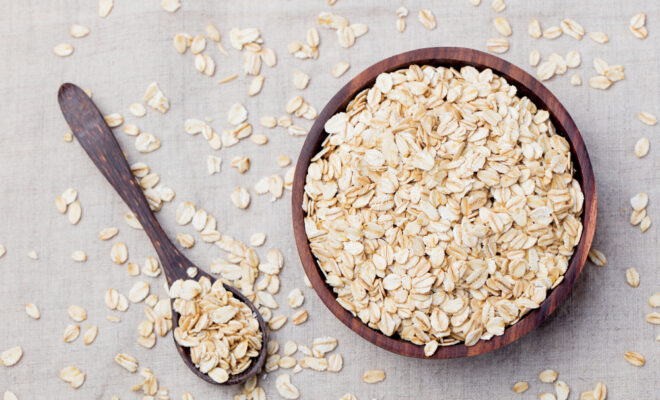Oats in a wood bowl with a wood soon