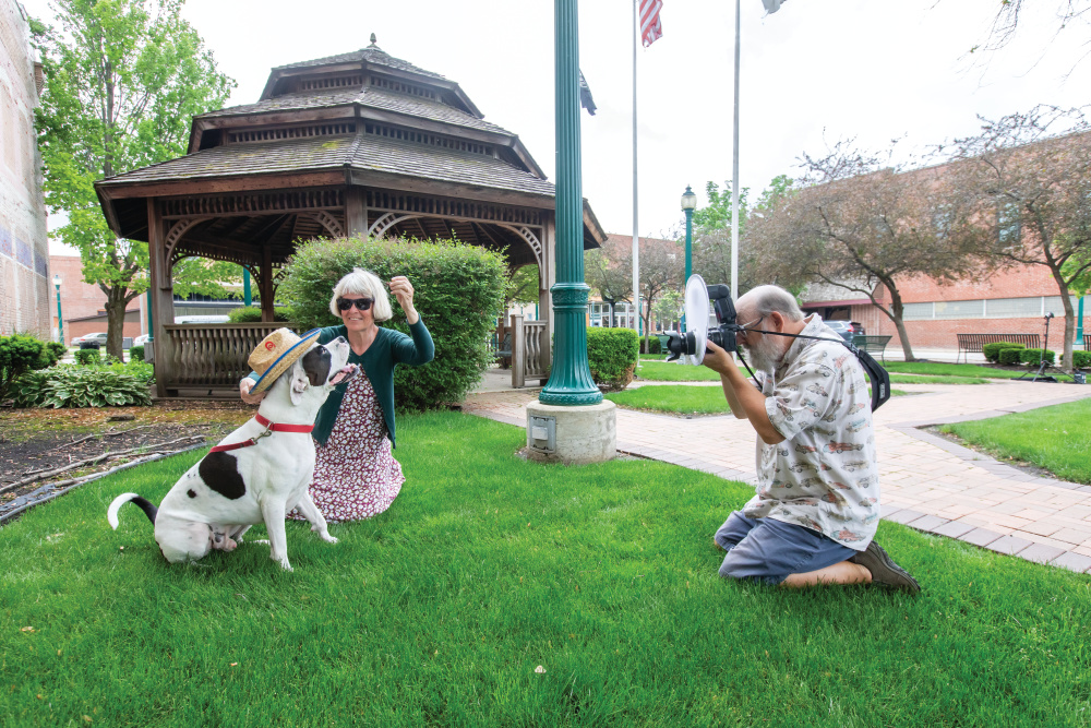 Cindy works with their dog, Joe, to pose for a picture Kirby is taking