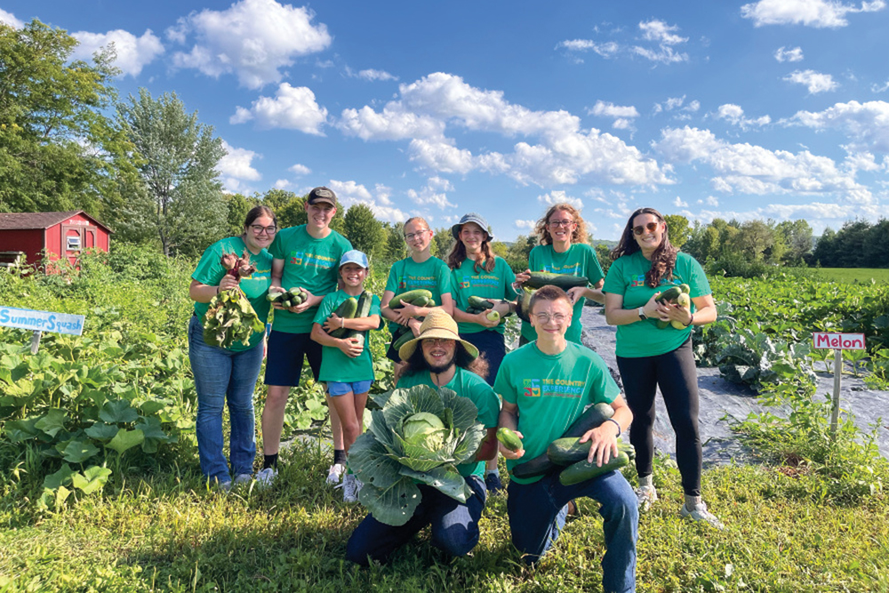 Summer camp staff and campers harvesting from the garden at The Country Experience, an Illinois farm stay 