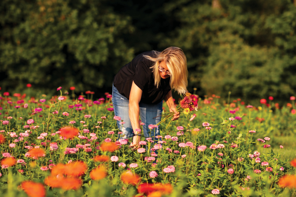 Woman picking flowers in a field at Wild Child Flower Farm