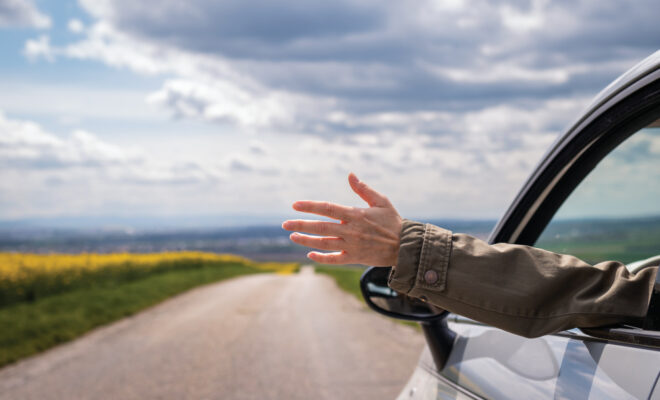 Woman waving out a car window