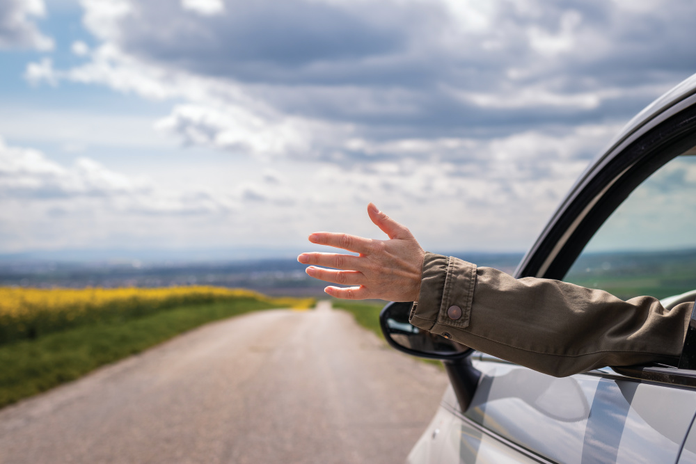 Woman waving out a car window