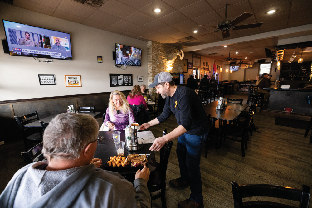 Rams Riverhouse employee serves food to customers 