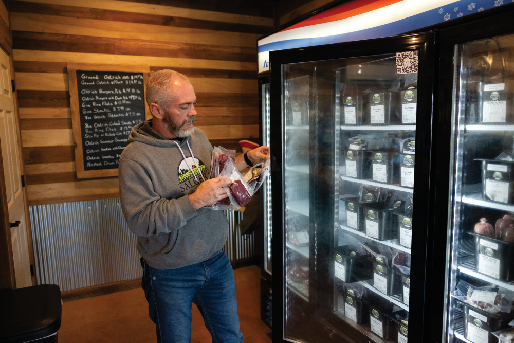 Paul Mollet stocks a cooler at Salger’s Ostrich Products