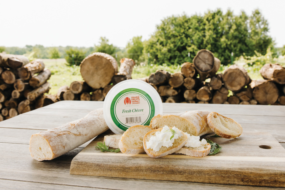 A tub of Prairie Fruits Farm and Creamery cheese spread and bread