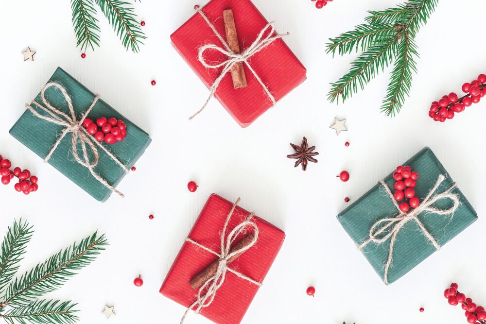 Wrapped gifts with greenery and berries around them