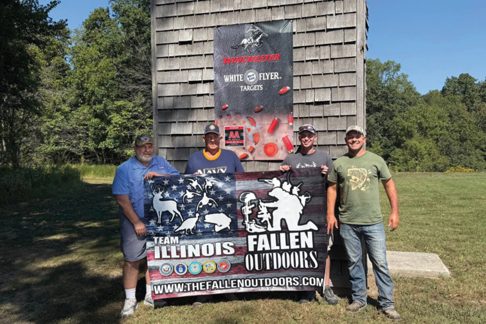 Team Illinois event with veterans holding a The Fallen Outdoors banner