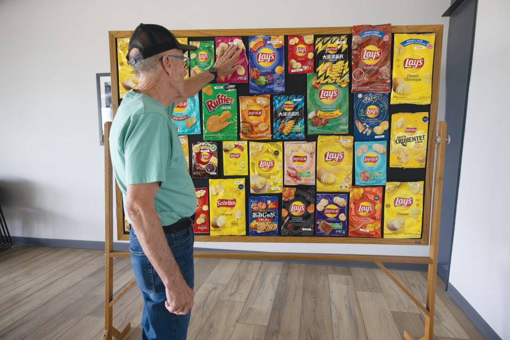 Tom Neumiller looking at a board with Lay's chips, which his family farm grows potatoes for